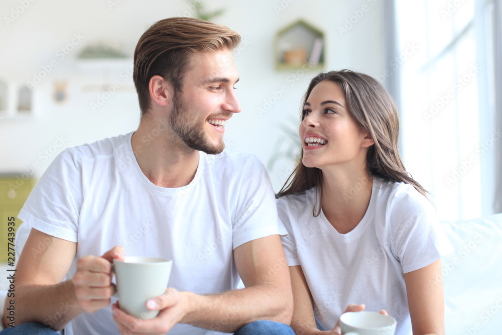 Cheerful young couple in the morning at home in the living room. Cheerful young couple in the morning at home in the living room.