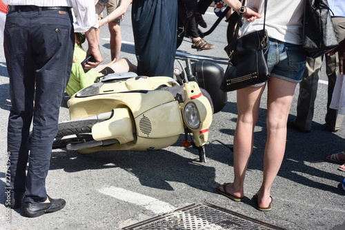 Primo piano di persone  accanto a una moto dopo un incidente stradale sulla strada della città photo
