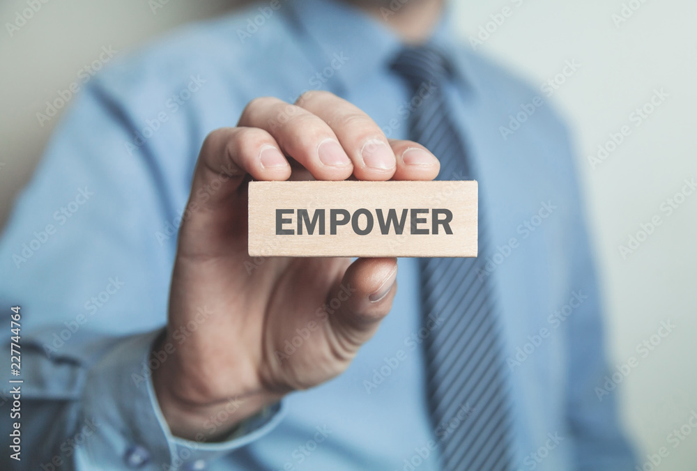 Businessman showing Empower word in wooden block. Business concept Businessman showing Empower word in wooden block. Business concept