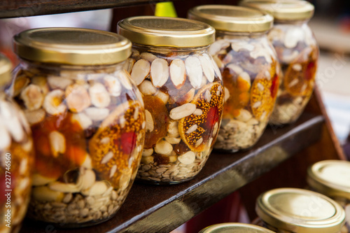 Healthy combination of natural honey with various nuts and dried fruits in jars