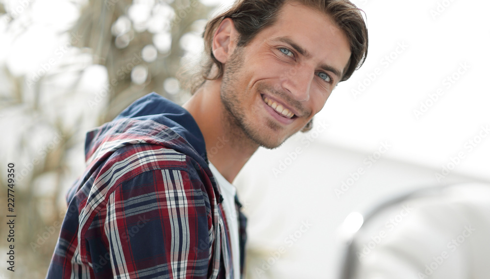 Fototapeta premium stylish young man working on laptop and looking at camera