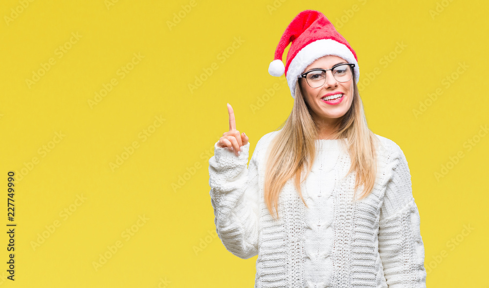 Young beautiful woman wearing christmas hat over isolated background pointing finger up with successful idea. Exited and happy. Number one. Young beautiful woman wearing christmas hat over isolated background pointing finger up with successful idea. Exited and happy. Number one.