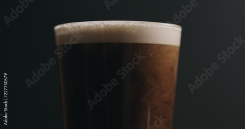 Carta da parati Closeup dark stout beer with bubbles over black background