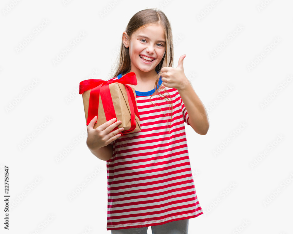 Young beautiful girl giving christmas or valentine gift over isolated background happy with big smile doing ok sign, thumb up with fingers, excellent sign Young beautiful girl giving christmas or valentine gift over isolated background happy with big smile doing ok sign, thumb up with fingers, excellent sign