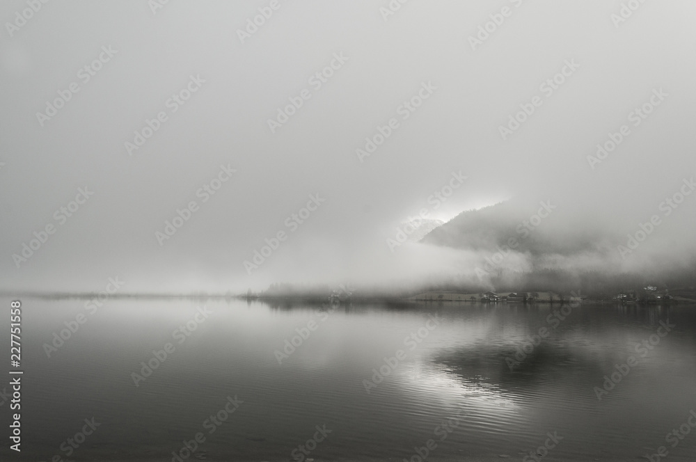 Early foggy wet morning on the lake between the mountains in Austrian Alps Early foggy wet morning on the lake between the mountains in Austrian Alps