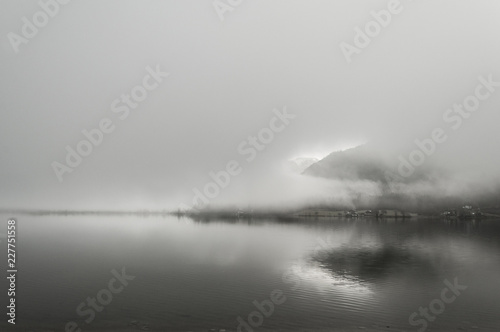 Early foggy wet morning on the lake between the mountains in Austrian Alps