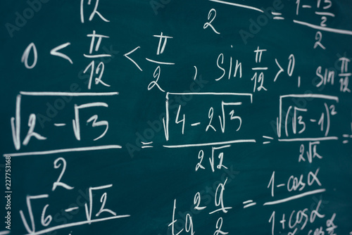 Mathematics formulas written on the blackboard. School, education.