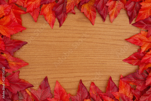 Autumn background with red and orange fall leaves on wood