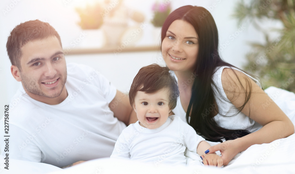 Cheerful family having fun together lying on a bed Cheerful family having fun together lying on a bed