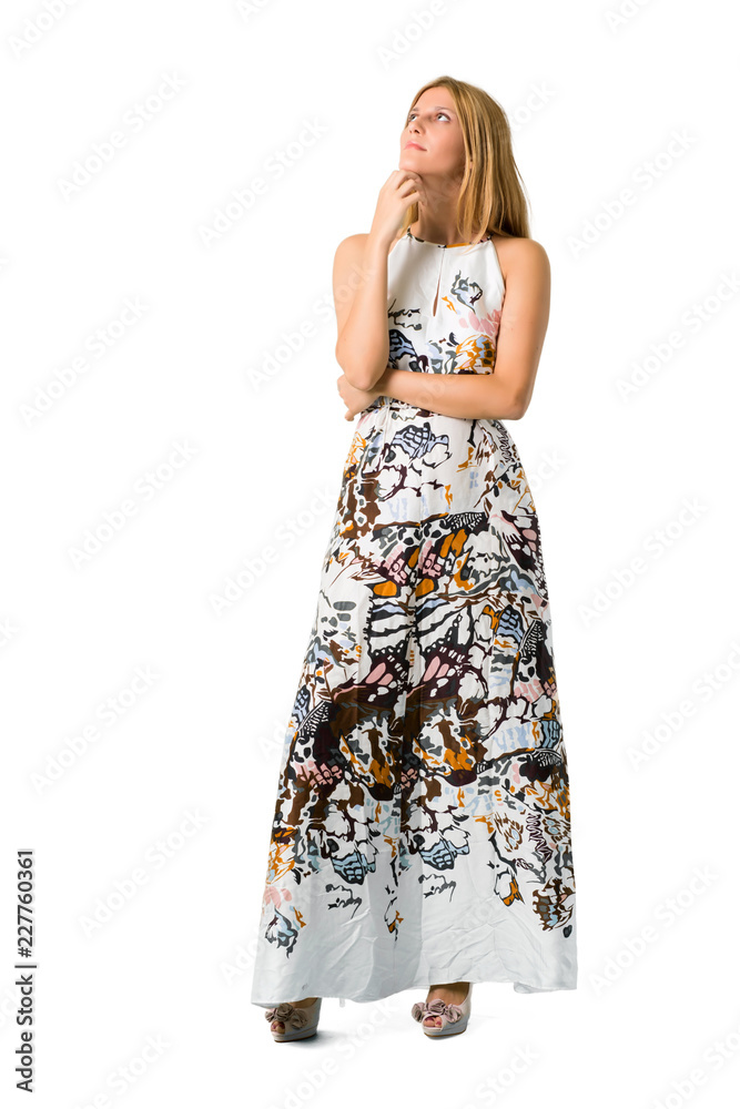 Blonde young girl in a summer dress standing and looking to the side on isolated white backgroun Blonde young girl in a summer dress standing and looking to the side on isolated white backgroun