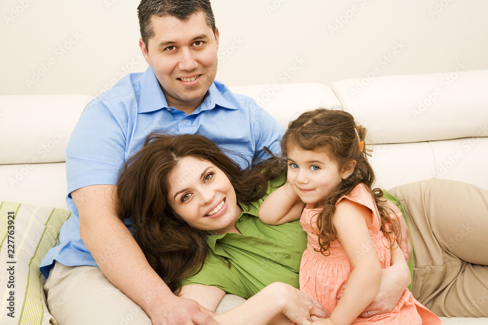 portrait of happy family sitting on sofa at home