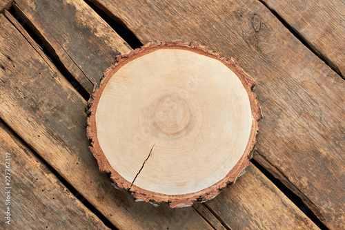 Round slice of wood on rustic backgorund. Tree trunk on rural wooden floor.