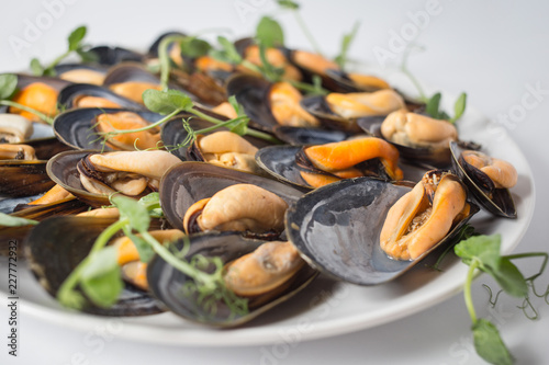Lots of mussels with green on the plate