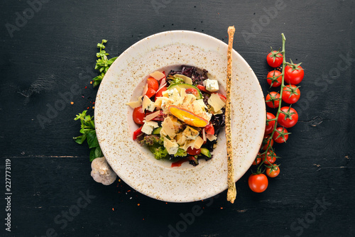 Salad of fresh vegetables with blue cheese and parmesan cheese. On the old background. Free copy space. Top view.
