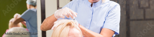 Hair loss concept - Female beautician makes injection of vitamins and minerals in the scalp.