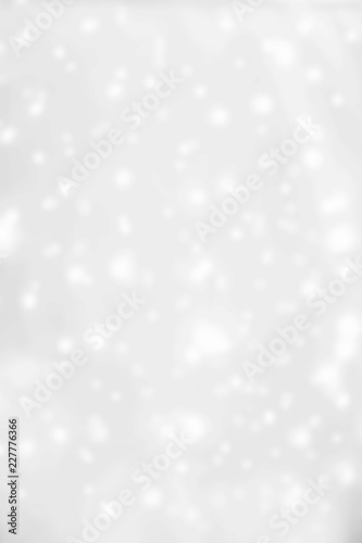 Silver  bokeh lights Christmas Background. Abstract Festive Card with white glittering stars.