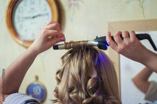 Blonde women curling hair
