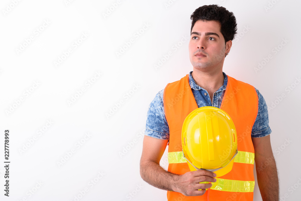 Young handsome Persian man construction worker against white bac Young handsome Persian man construction worker against white bac