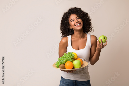 Woman holding fruits assortment served on plate photo