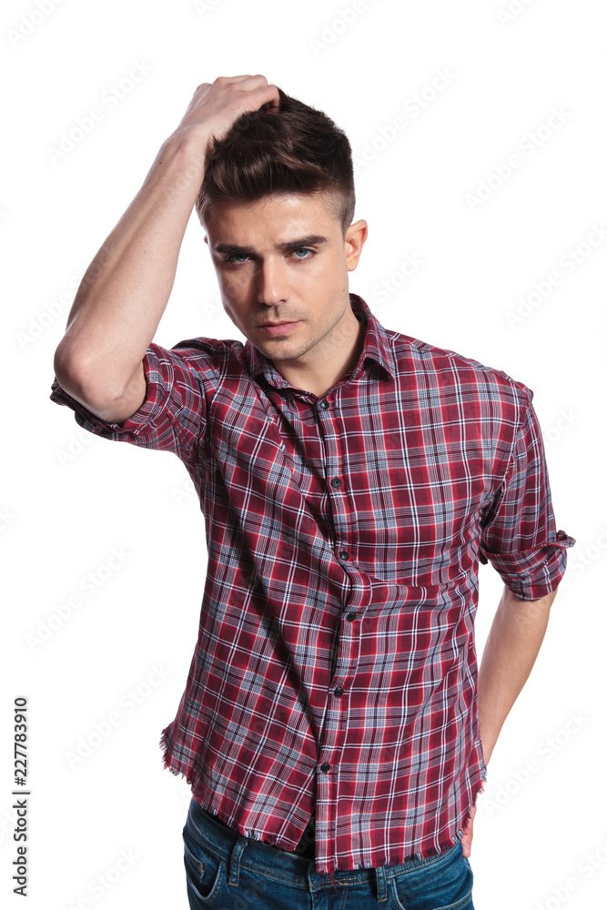 portrait of handsome man wearing a plaid shirt fixing hair portrait of handsome man wearing a plaid shirt fixing hair