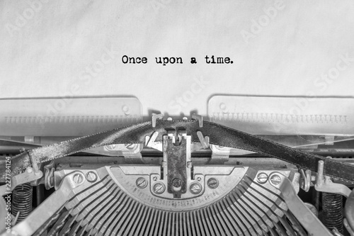 the word once upon a time typed on a vintage typewriter on a sheet of paper. writer, journalist.