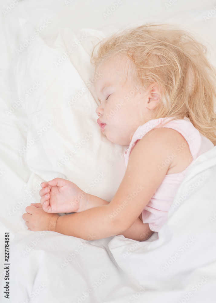 little blonde baby girl sleeping on a bed. Top view. Space for text little blonde baby girl sleeping on a bed. Top view. Space for text