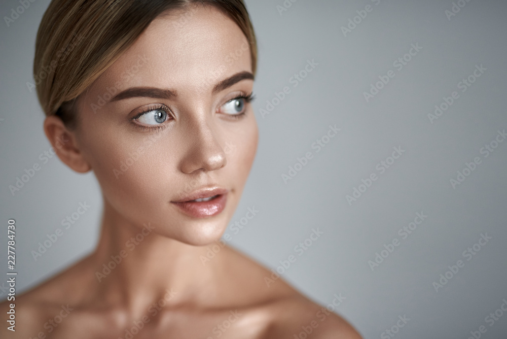 Fototapeta premium Zainteresowanie. Młoda jasnowłosa dama o czystej skórze o lakonicznym makijażu i patrząca w dal stojąc samotnie