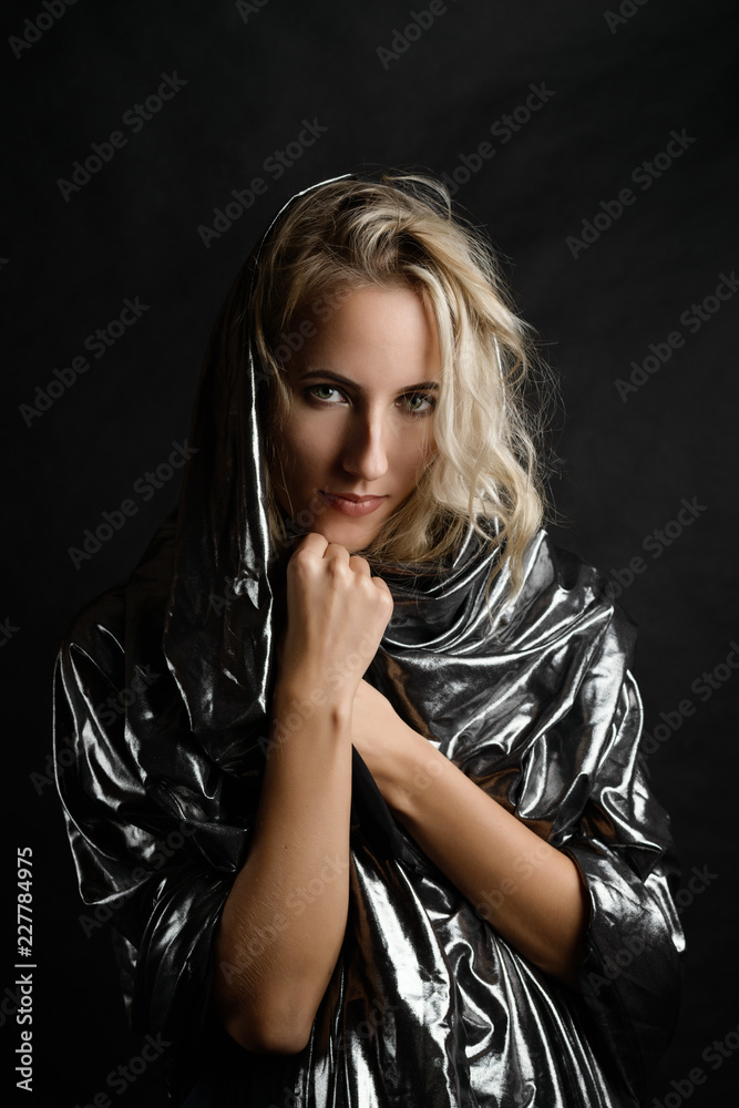 Portrait of beautiful woman in cape on dark background. Portrait of beautiful woman in cape on dark background.