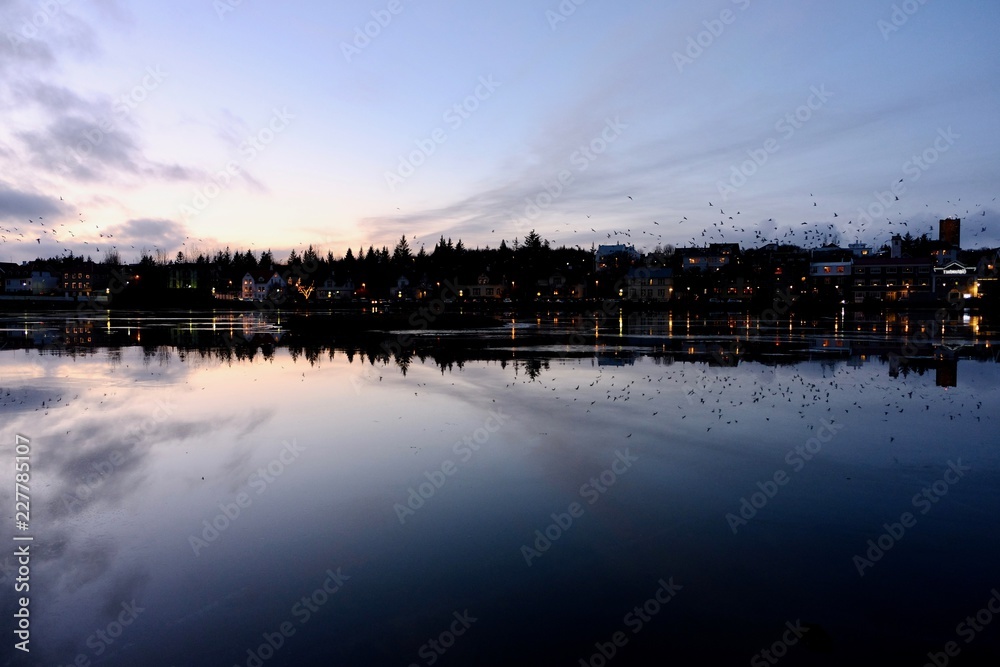 Obraz premium The buildings were reflected in the frozen lake during dusk
