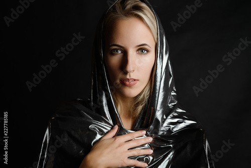 Obraz na plátně Portrait of beautiful woman in cape on dark background.