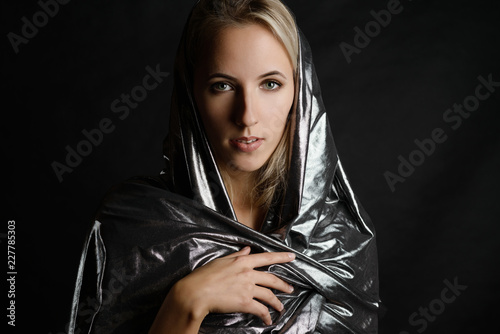 Obraz na plátně Portrait of beautiful woman in cape on dark background.