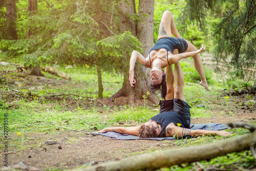 Giovane coppia pratica acroyoga in un bosco naturale photo