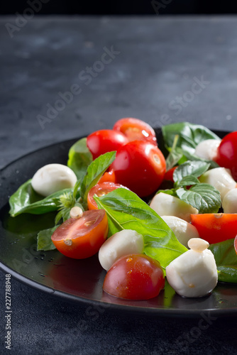 Wallpaper Mural Tasty and beautiful Caprese salad on the black ceramic plate, close up Torontodigital.ca