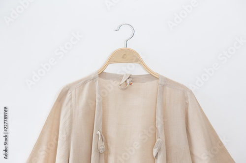 Natural colour blouse is clothes hanging on white background. © Pornpawit