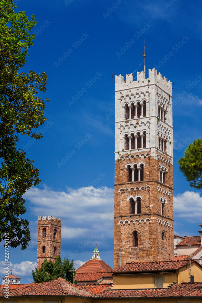 Ancient medieval  bell towers rise above Lucca historic center roofs
