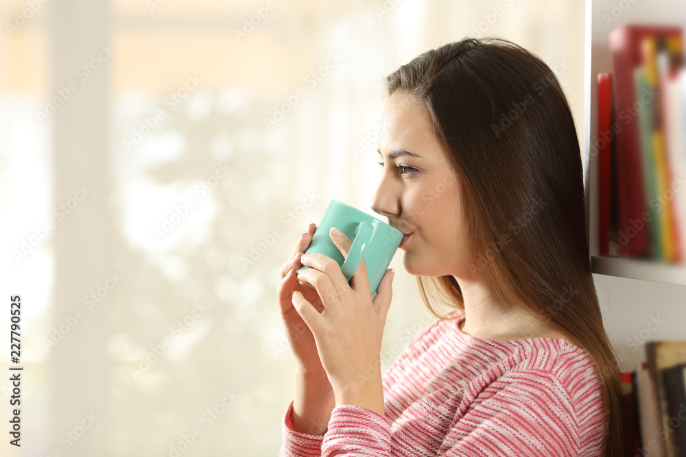 Relaxed woman drinking coffee leaning on shelves Relaxed woman drinking coffee leaning on shelves