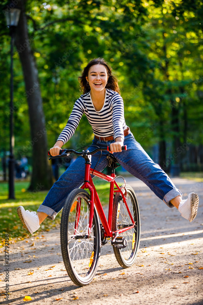 Obraz premium Urban biking - woman riding bike in city park