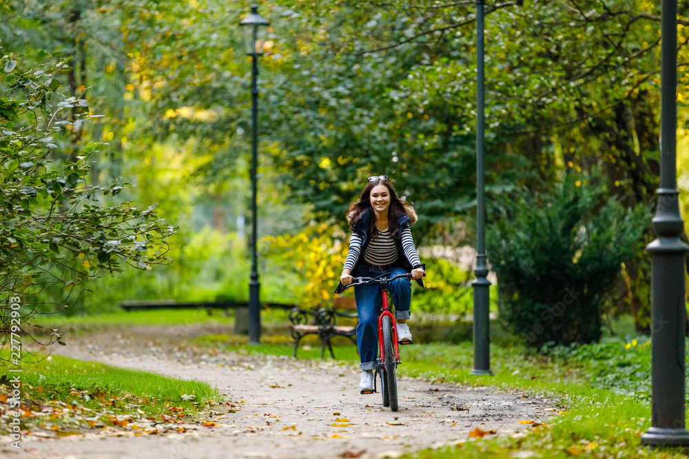 Urban biking - woman riding bike in city park Urban biking - woman riding bike in city park