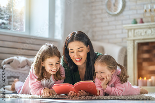 mother reading a book to her daughters