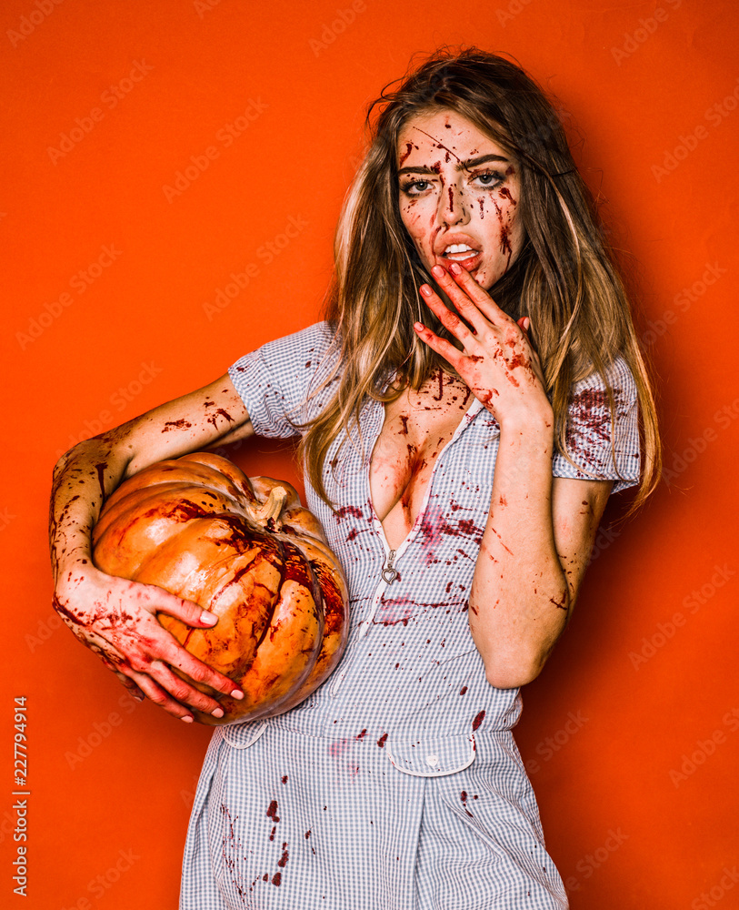 Beautiful Young woman as sexy vampire - halloween concept. Scary bloody  zombie girl with pumpkin. Woman with red blood and with blond hair. Stock  Photo | Adobe Stock