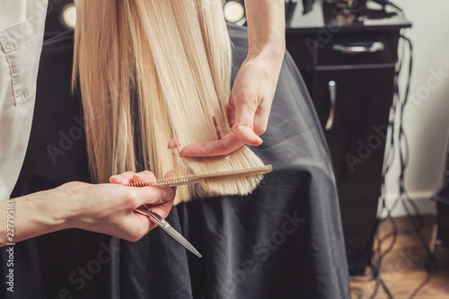 Hairdresser is cutting long hair in hair salon