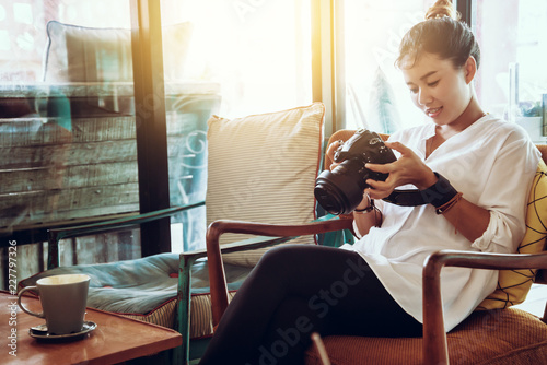 Asian woman sitting relax on the sofa. Viewing photos in camera