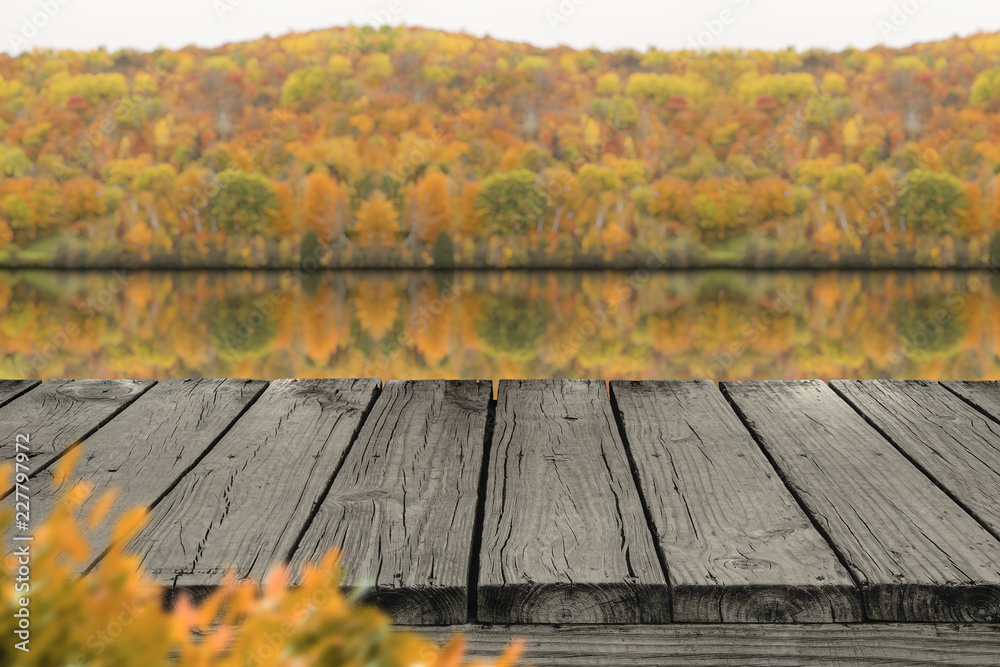 Φωτογραφία Old wood deck with blur background of lake and forest in Autumn , for display or montage your products