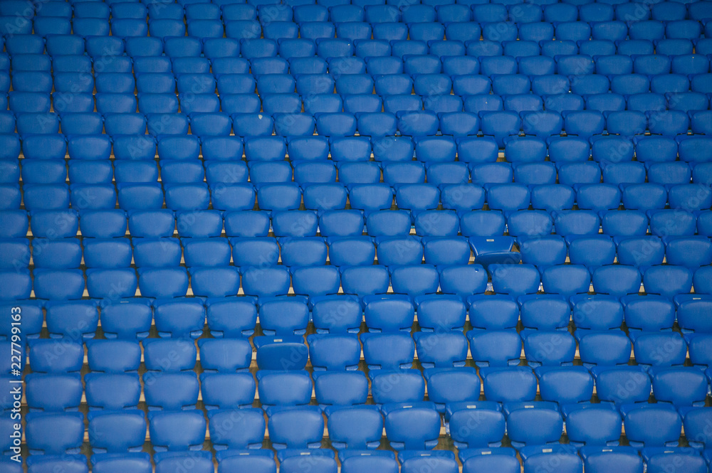 Naklejka premium Niebieskie puste miejsca na stadionie piłkarskim. Żółte schody z kilkoma sektorami.