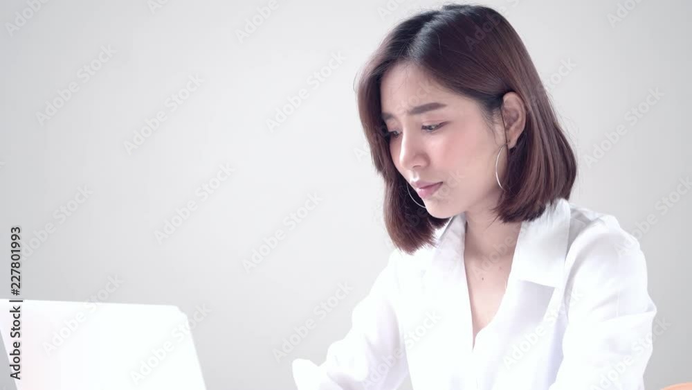 Young Asian woman working on computer and get a good result then happy Young Asian woman working on computer and get a good result then happy