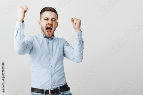 Successful and excited business man cheering with joy while