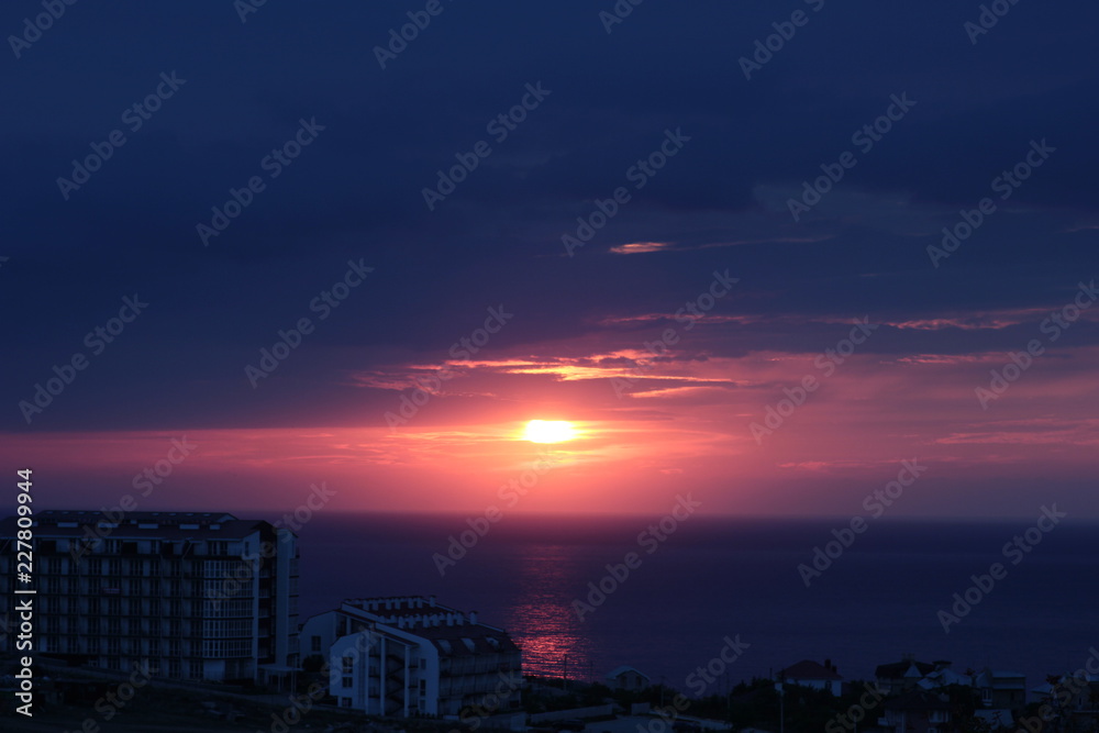 the sun setting over the sea horizon