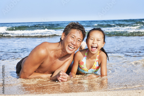 father and daughter at the beach playing © AnnMarie