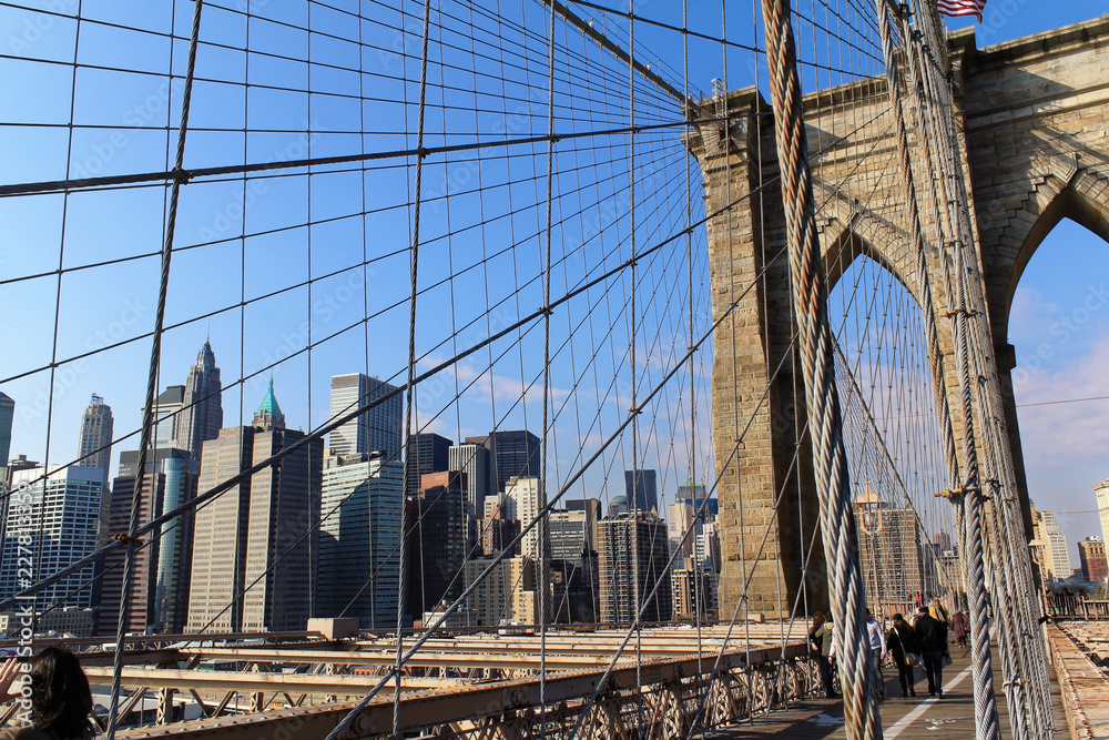 Obraz premium New York, USA - November 22, 2010: Spectacular views of the Brooklyn Bridge with all its characteristic metal wires and the pedestrian walkway