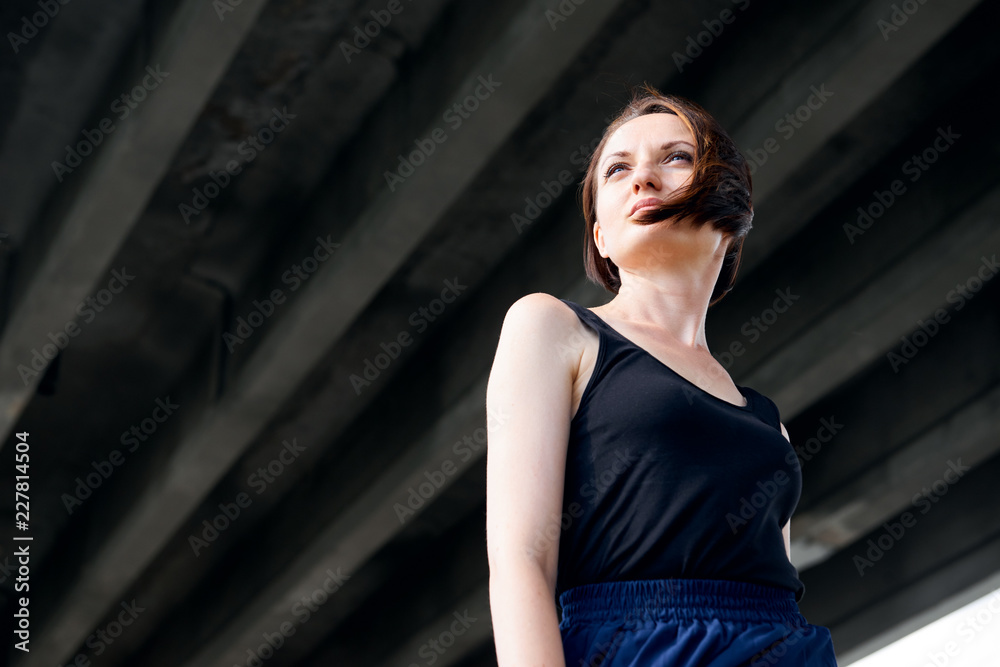 young girl posing under the bridge, dressed in black, modern architecture young girl posing under the bridge, dressed in black, modern architecture